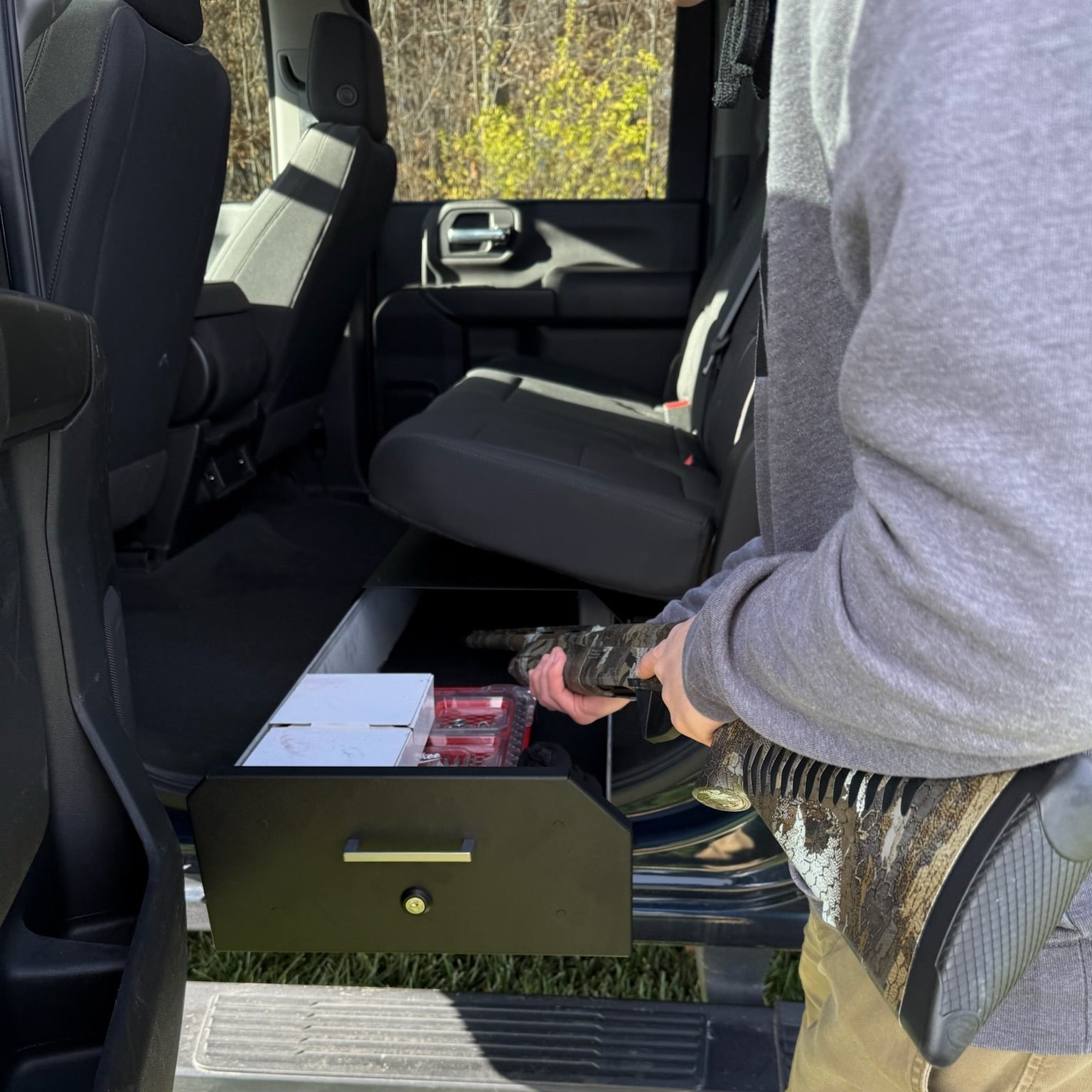 Ram Gear-Guard Under-Seat Locker with the door open with the carpet option showing how it can be used. The locker is a high-quality powder coated galvanealed steel.