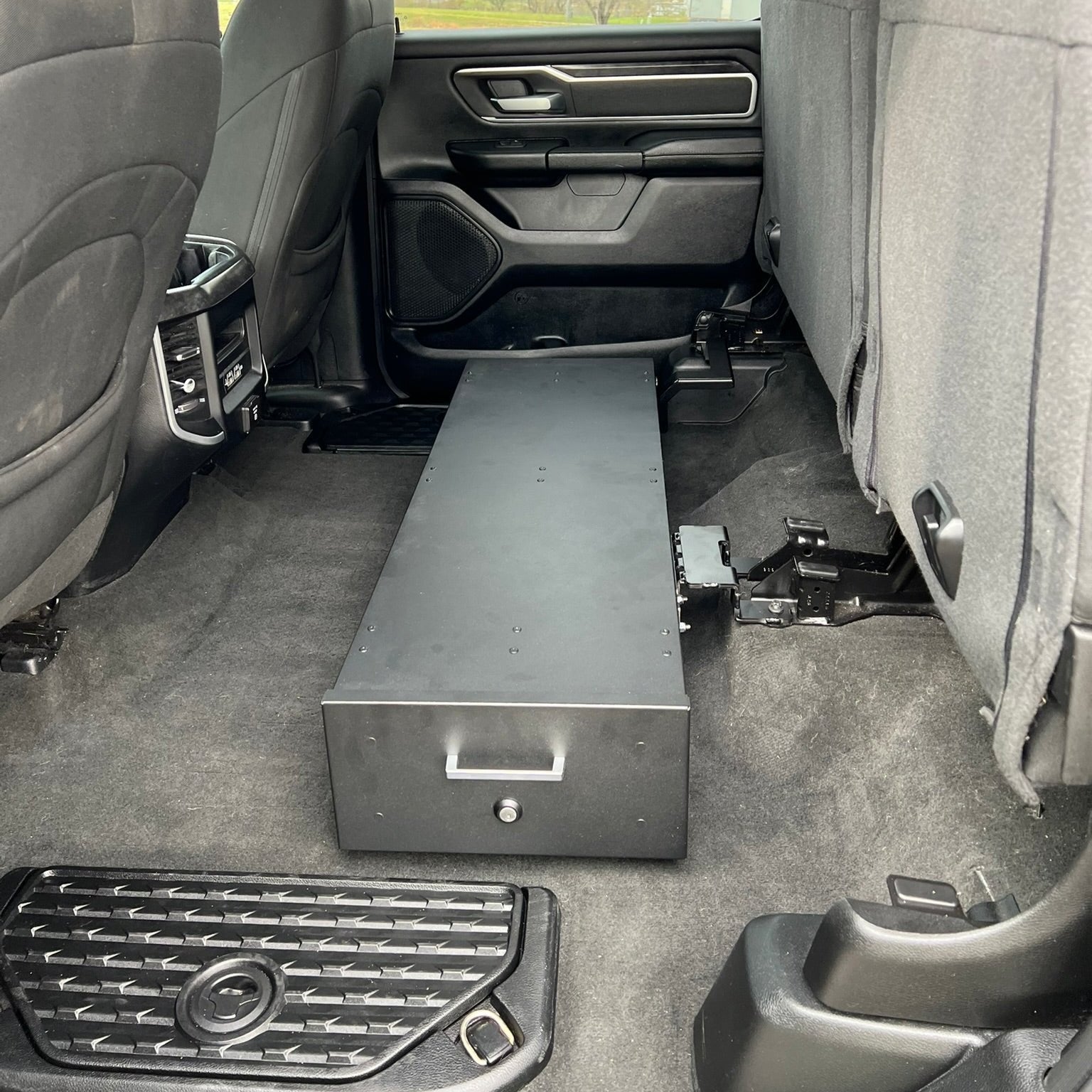 Ram Gear-Guard Under-Seat Locker with the door closed on a and installed in the truck. The locker is a high-quality powder coated galvanized steel.